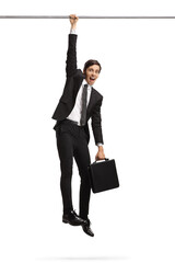 Businessman hanging and holding onto a bar