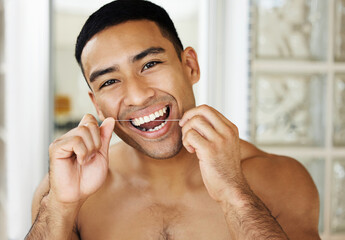 If you want a good-looking smile, you gotta floss. Closeup shot of a handsome young man applying...