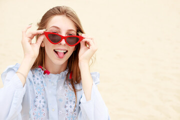 a friendly portrait of a woman in red glasses in the summer. free space for text