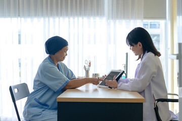Cancer patient woman wearing head scarf after chemotherapy consulting and visiting doctor in...