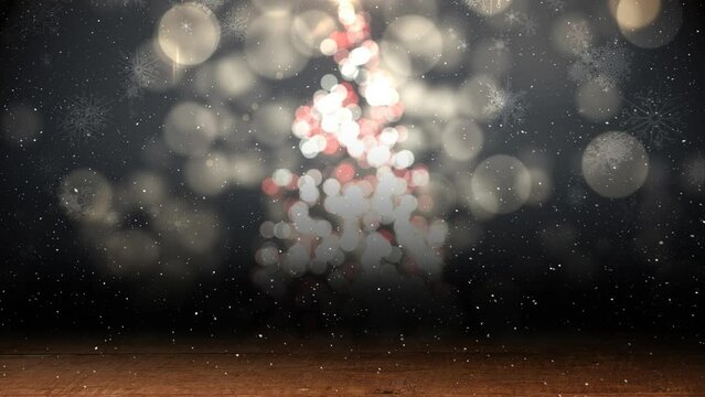 Animation of snow falling in seamless loop over glowing christmas tree in background
