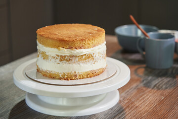 cake in preparation. biscuit layers smeared with cream