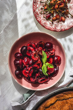 Freshly baked cherry pie and seedless half cherry's on table