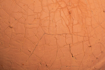 The cracked paint on an old metallic surface.