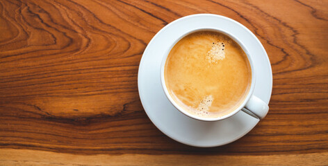 Top view of coffee cup with foam on wooden table.close-up