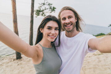 Portrait of two positive lovely people cuddle make selfie recording video beach date outside