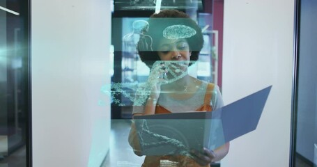 Animation of dna strand spinning over african american businesswoman using smartphone in office - Powered by Adobe