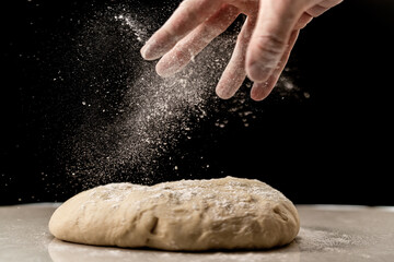 Obraz premium Sprinkling flour on the dough for the preparation of Brioche feuilletée tressée pastry