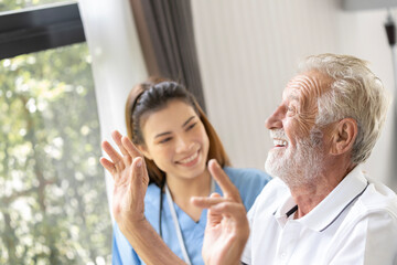 Fototapeta premium Man being cared for by a private Asian nurse at home suffering from Alzheimer's disease to closely care for elderly patients