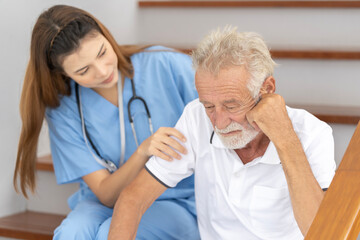 Man being cared for by a private Asian nurse at home suffering from Alzheimer's disease to closely care for elderly patients