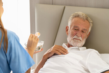 Man being cared for by a private Asian nurse at home suffering from Alzheimer's disease to closely care for elderly patients