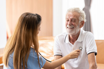 Man being cared for by a private Asian nurse at home suffering from Alzheimer's disease to closely care for elderly patients