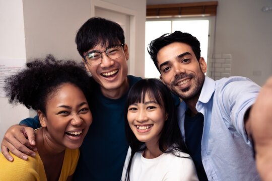 Happy friends from diverse cultures and races taking selfie with back lighting Youth and friendship concept with young people having fun together.African American and Asian working,studying concept.