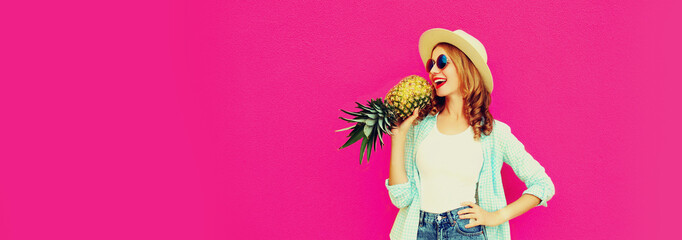 Summer portrait of happy laughing young woman signing having fun with pineapple on pink background,...