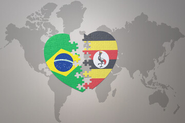 puzzle heart with the national flag of brazil and uganda on a world map background.Concept.