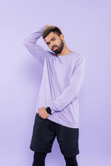 bearded african american man in sweater posing isolated on purple.