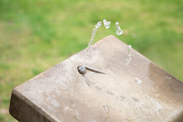 Stream of water pours from the outdoor water fountain