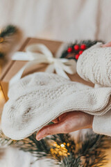 Warm Christmas Socks held in woman hands with gift box on background 