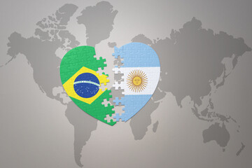puzzle heart with the national flag of brazil and argentina on a world map background.Concept.