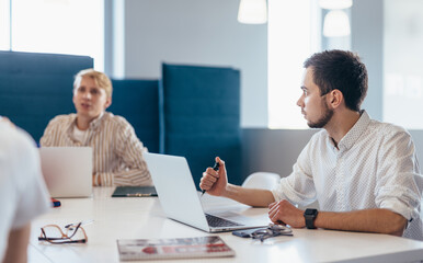 People are meeting at a desk at work