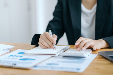 Close up woman accountant using calculator. Business woman calculating monthly expenses, managing...