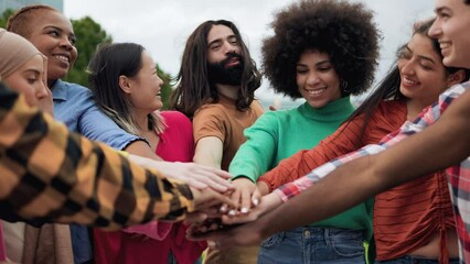 Young multiethnic group of people stacking hands together outdoor - Teamwork diversity and unity concept