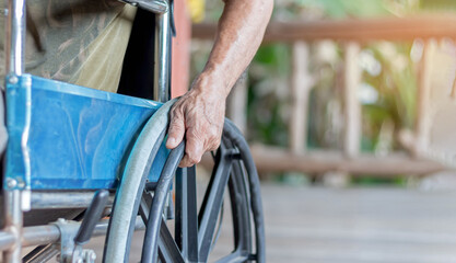 Close-up of a senior sitting on a wheelchair at home Handicapped elderly man in a problematic wheelchair The concept of elderly people with disabilities
