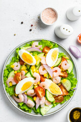 Healthy low carb shrimp egg salad on plate on light background. Top view, copy space.