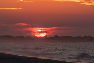 Fototapeta na wymiar The sun rising behind clouds over Cape May national wildlife refuge north of Cape May New Jersey
