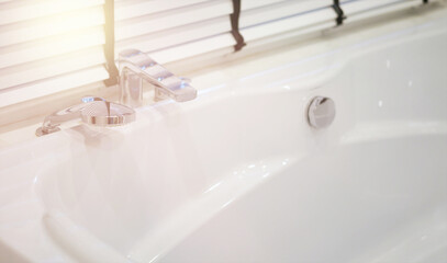 bathtub with faucet beside window interior view