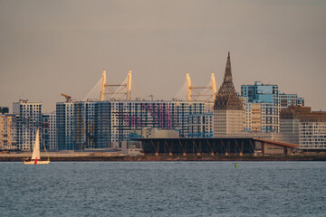 The residential complex under construction on the embankment of the Neva River on Vasilievsky island in sunset, bulk island, construction cranes