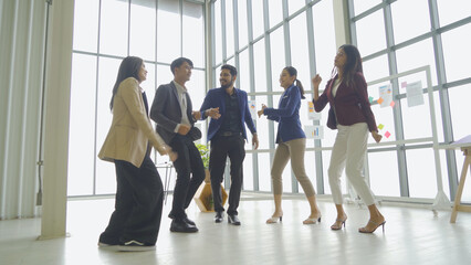 Fototapeta premium A relax happy group of Asian business team employee people having fun, doing activity, dancing in party in meeting room office. Business analysis. People lifestyle. Celebration. Cooperation