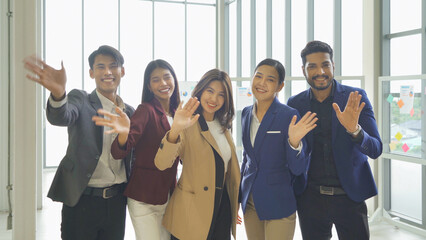 Portrait of a group of smiling Asian business people meeting, discuss, and working in a meeting room in office seminar, present ideas with colleagues. People lifestyle. Corporate teamwork