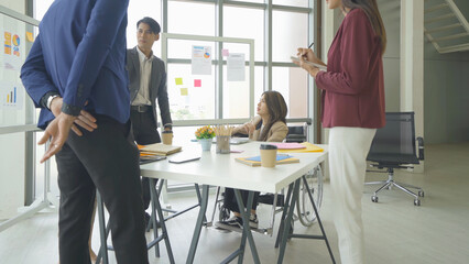 Disabled people with a group of Asian business team talk, communicate, discuss, and work in meeting room office, present ideas to colleagues. People lifestyle. Corporation