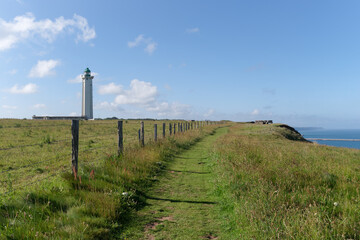 Fototapeta na wymiar Coastal path and lighthouse of the Antifer cape in Normandy coast