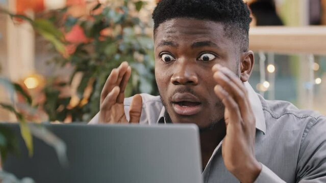 Close-up young businessman looking at laptop screen getting bad news surprised shocked man holding head found error incorrectness in electronic document virus in application loss important information