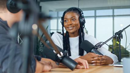 Female Host Talking to a Guest Friend on a Podcast Radio Station in the Studio. African American and European Record Podcast and Discuss Social Issues, Business Radio Show. - obrazy, fototapety, plakaty