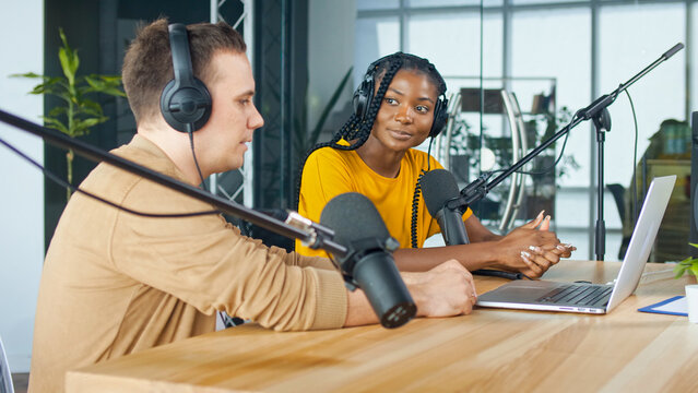 A Male Presenter Communicates with a Guest, an African American, During a Radio Broadcast at a Table in a Recording Studio, Broadcasts a Live Radio Interview With Spbd.