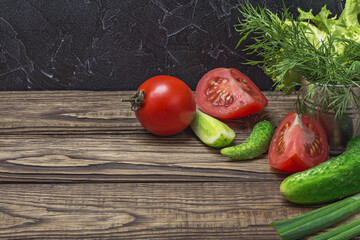 Fresh organic vegetables on a wooden table tomatoes, onions, cucumbers.