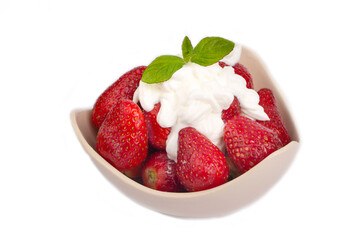 Glass bowl of strawberries with whipped cream.