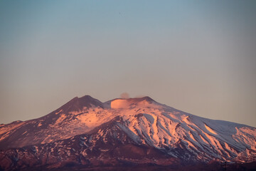 Panoramic view of snow capped Mount Etna volcano during sunrise seen from Taormina, island Sicily,...