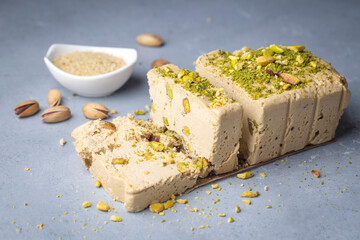 Sesame halva with pistachios on grey background. Top view. Copy space. Traditional middle eastern sweets. Jewish, turkish, arabic national dessert. Turkish delight.