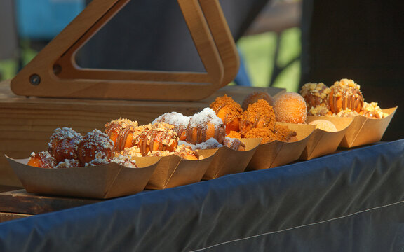 Tasty little mini doughnuts with variations of different toppings at farmers street food market in Prague