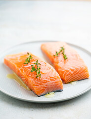 Fresh salmon fillet with herbs on a plate for delicious salmon steak.