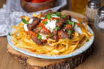 Turkish food; Cokertme Kebab - Beef meat kebab with yoghurt and french fries