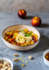 Healthy fruit salad with nectarine, ricotta cream with pistachios and honey