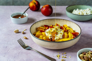 Healthy fruit salad with nectarine, ricotta cream with pistachios and honey