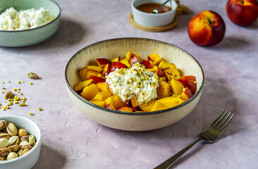 Healthy fruit salad with nectarine, ricotta cream with pistachios and honey