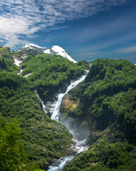 Beautifull high waterfall in mountains with green forest