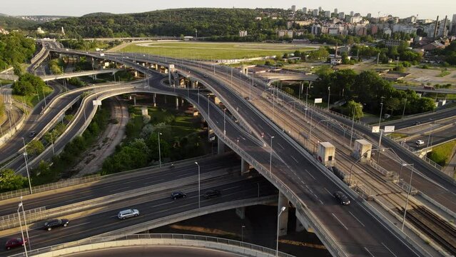 Aerial skyline cityscape view of Belgrade, Serbia, in the morning. Aerial  drone view of   Ada Ciganlija lake, hippodrome and traffic driving over intersection in Belgrade. Urban scene 4k